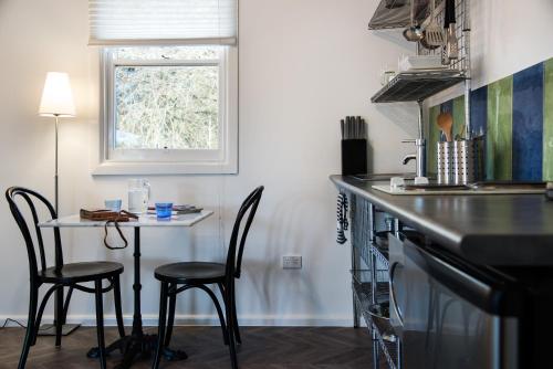 a kitchen with a table and chairs and a window at Lake Daylesford Apartments 5 in Daylesford