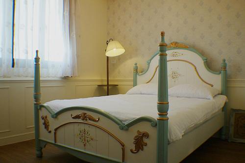 a bedroom with a canopy bed with a lamp at Yo Muma Homestay in T'ien-wei