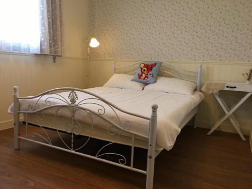 a white bed with a hello kitty pillow on it at Yo Muma Homestay in T'ien-wei