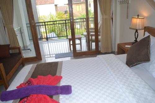 a bedroom with a bed with a red dress on it at Master Homestay in Amed