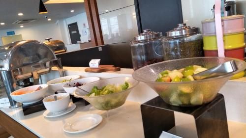 a kitchen counter with bowls of vegetables on it at Hotel Transit Kuala Lumpur in Kuala Lumpur