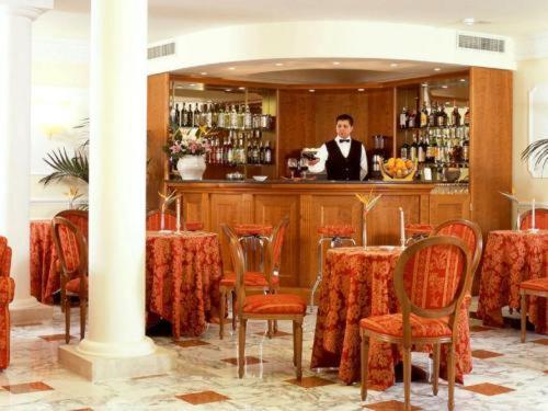 a man standing at a bar in a restaurant at Hotel Holiday Sul Lago in Bolsena