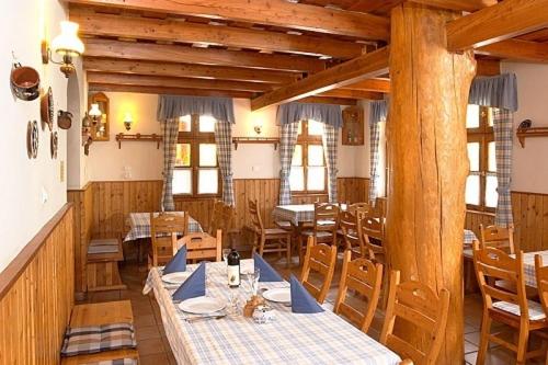 a dining room with wooden tables and chairs at Tapolca Fogadó in Miskolctapolca