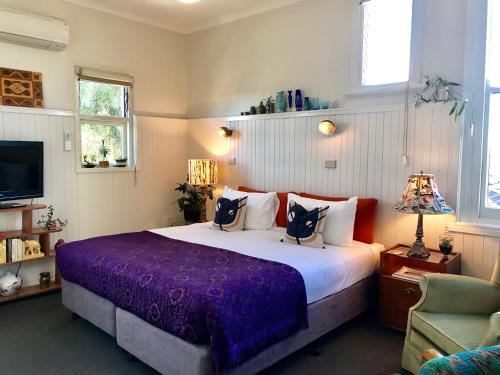 a bedroom with a large bed and a tv at Vine Valley Inn in Cessnock