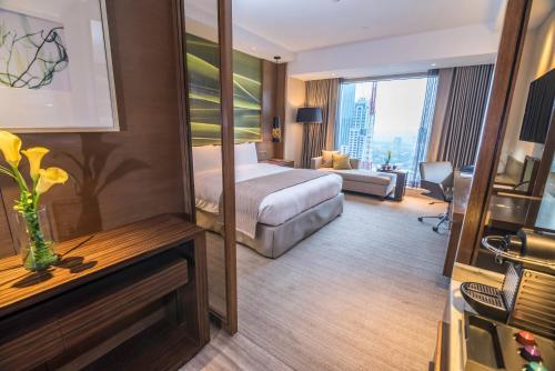 a hotel room with a bed and a large window at Marco Polo Ortigas Manila in Manila