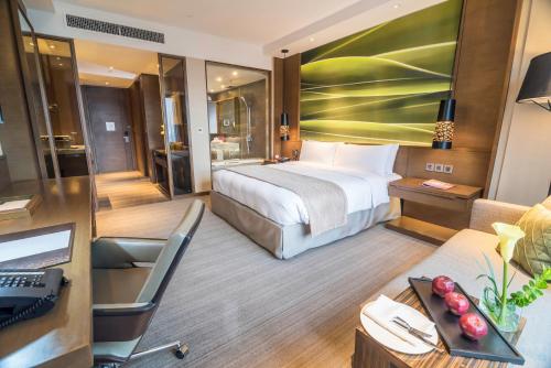 a hotel room with a bed and a desk at Marco Polo Ortigas Manila in Manila
