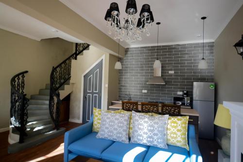 a living room with a blue couch and a chandelier at Luxe Wilderness - Private Villas, Free Breakfast, 2km from City Centre in Nuwara Eliya