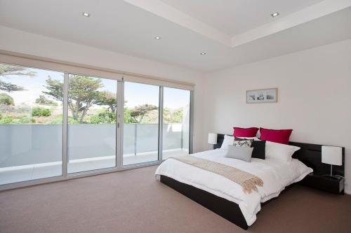 a bedroom with a large bed and a large window at Four Kings 3 in Anglesea