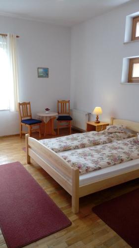 a bedroom with a bed and two chairs and a table at Gospodarstwo Agroturystyczne-Pensjonat SAD in Podgórzyn