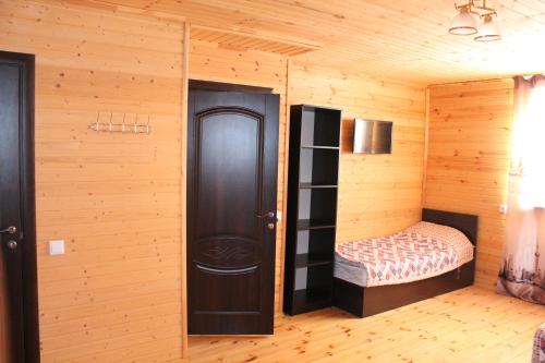 um quarto com uma cama e uma parede de madeira em Guest house Ozernaya em Cholpon-Ata