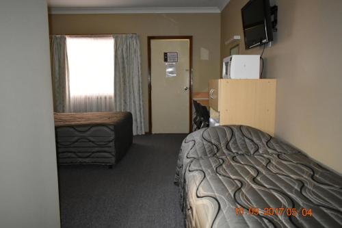 Una cama o camas en una habitación de Cooee Motel