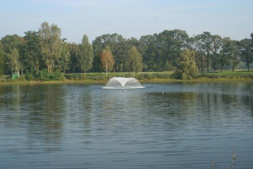 a fountain in the middle of a lake at Golfhotel Rheine Mesum in Rheine