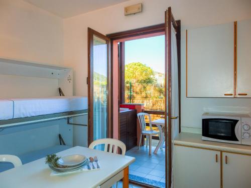 a small room with a bed and a kitchen with a table at Camping Lacona Pineta in Capoliveri