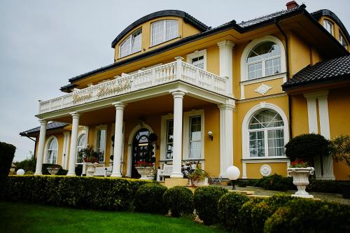 a large yellow house with a white balcony at Dworek Hetmanski in Stargard