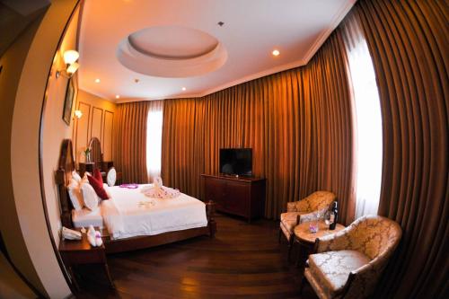 a hotel room with a bed and two chairs at An Loc Hotel & Spa in Thanh Bình