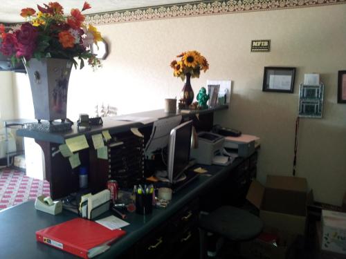 a desk with a vase of flowers on top of it at Stonebrook Inn in Counce