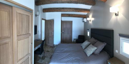 1 dormitorio con 1 cama y puerta de madera en Villa HOVANES, en Le Lavandou