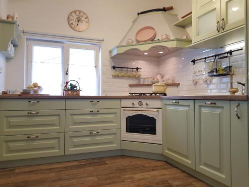 a kitchen with white cabinets and a stove at House Anastazia Pool & Panoramic Sea View in Lovran