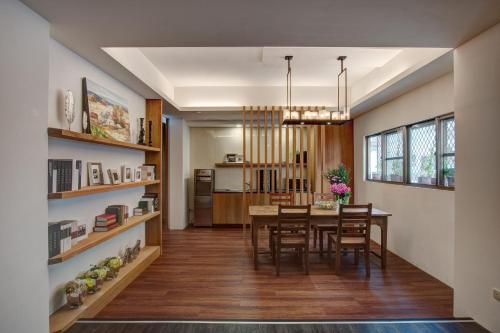 una sala da pranzo e una cucina con tavolo e sedie di EG Hostel a Nantou