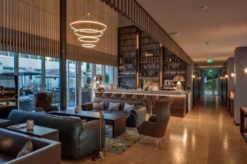 a restaurant with leather furniture and a bar at Hotel Sempachersee in Nottwil