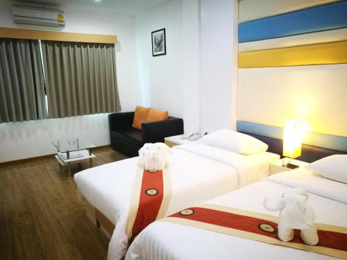 a hotel room with two beds with teddy bears on them at Eastpana Executive Residence 304 Prachinburi in Si Maha Phot