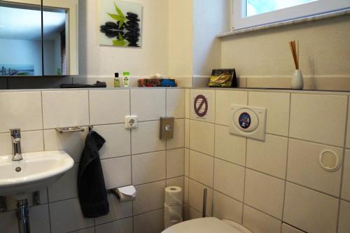 a bathroom with a toilet and a sink at BodenSEE Apartment Meckenbeuren Neuhaldenstrasse in Meckenbeuren