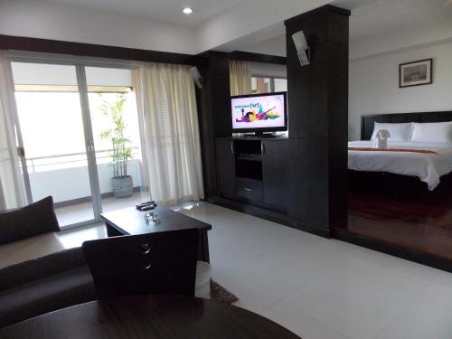 a hotel room with a bed and a television at Eastpana Executive Residence 304 Prachinburi in Si Maha Phot
