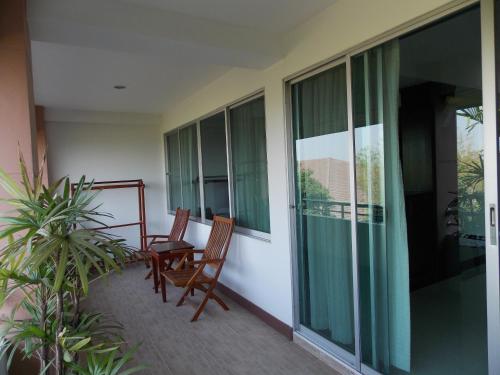a balcony with two chairs and glass windows at Eastpana Executive Residence 304 Prachinburi in Si Maha Phot