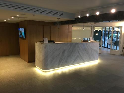 a lobby with a counter with lights on it at Mandrino Hotel in Thessaloniki