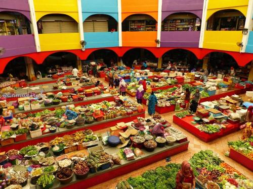a group of people standing in a market with lots of vegetables at Laman Kurnia Holiday House in Kota Bharu