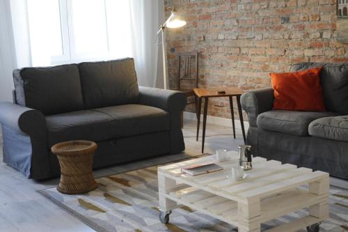 a living room with two couches and a coffee table at MiłoTu - Apartament Marszałkowski in Warsaw