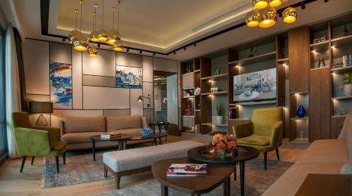 a living room with a couch and chairs and tables at Somerset Maslak Istanbul in Istanbul