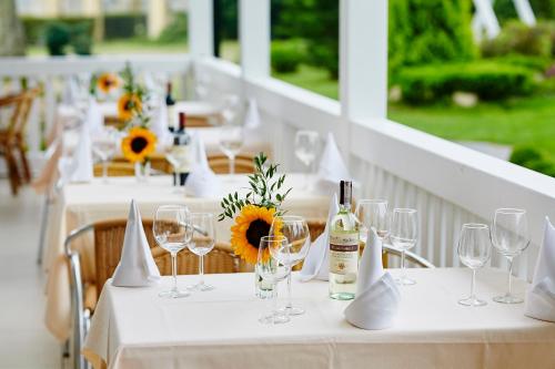 een tafel met wijnglazen en bloemen erop bij Dworek Hetmanski in Stargard