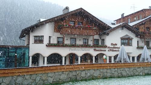 un edificio en la nieve delante en Residence Ploner, en San Cassiano