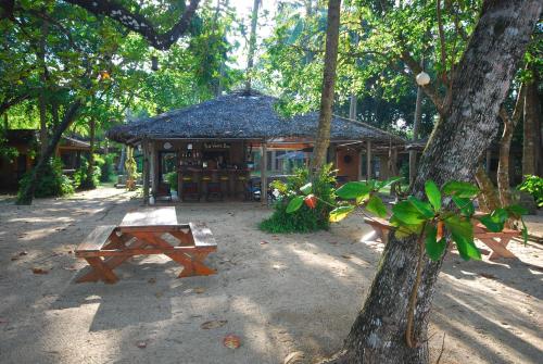 a building with a table and a bench in front of it at Melina Beach Front Bungalows in Tha Lane Bay