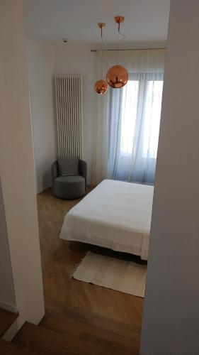 a bedroom with a bed and a chair and a window at Stella CasaBono in Sulmona