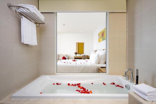 a bathroom with a bath tub with red flowers on it at Rosaka Nha Trang Hotel in Nha Trang