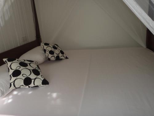 two pillows sitting on a bed in a room at New Jaya Villa in Bentota