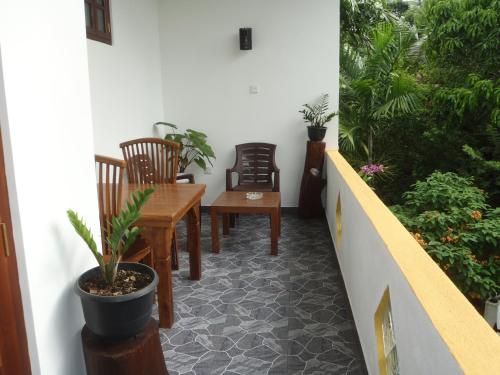 a balcony with a table and chairs and plants at New Jaya Villa in Bentota