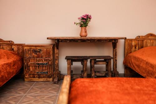 a bedroom with two beds and a table with a vase on it at Guest house Dilijan Orran in Dilijan