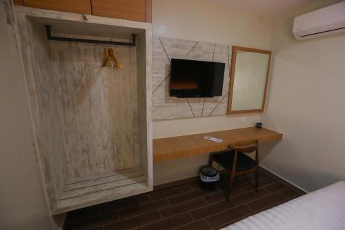 a room with a desk with a tv and a mirror at Pantai Regal Hotel in Kuantan