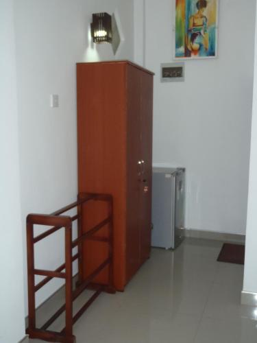 a large wooden cabinet in a room with a refrigerator at New Jaya Villa in Bentota