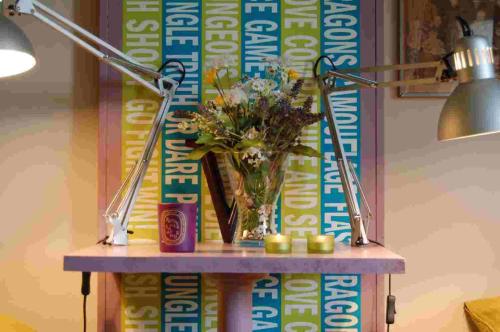 a vase of flowers on a table with a lamp at B&B Binot in Carmagnola