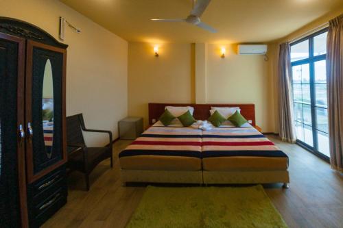 a bedroom with a bed with a dresser and a mirror at Annama Lodge and Dive in Hoarafushi