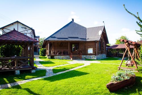 a house with a yard with grass and a building at Tsisarske Urochyshe in Rozgirche