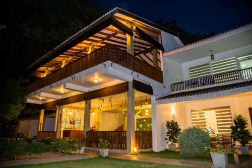 a house with a lit up facade at night at Anantamaa Hotel in Trincomalee