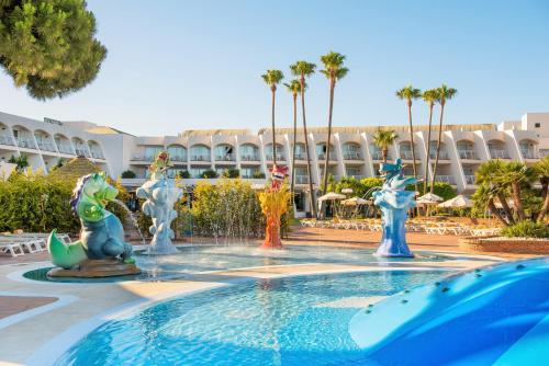 a pool with a fountain in front of a resort at Iberostar Waves Royal Andalus in Chiclana de la Frontera
