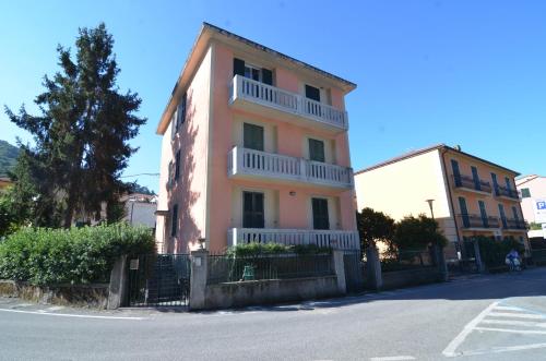 een roze gebouw met witte balkons in een straat bij Levanto Rentals in Levanto