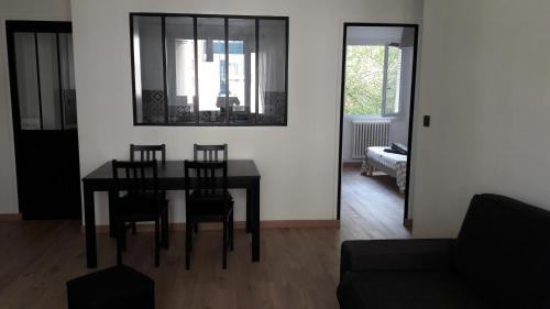 une salle à manger avec une table, des chaises et un canapé dans l'établissement Modernité et design Part Dieu, à Lyon