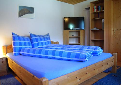 a blue bed with blue pillows in a room at Studio Schija in Sankt Antönien